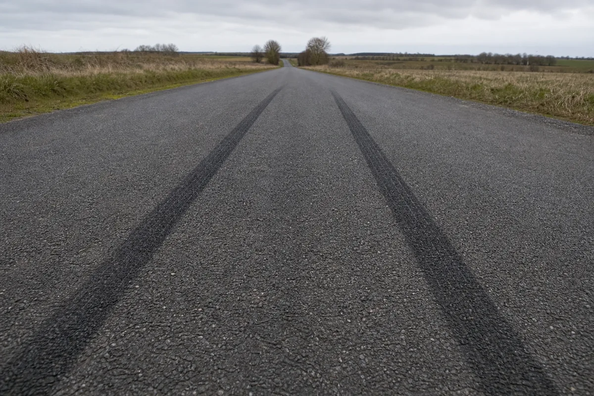 Traces de freinage marquées sur l’asphalte d’une route de campagne